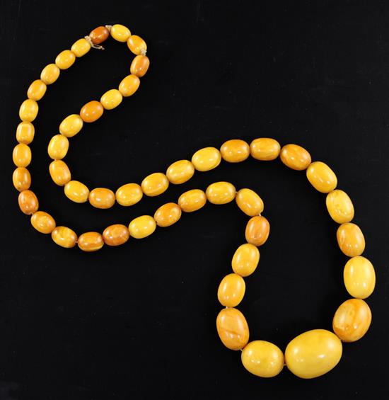 A single strand graduated oval amber bead necklace, 72cm.